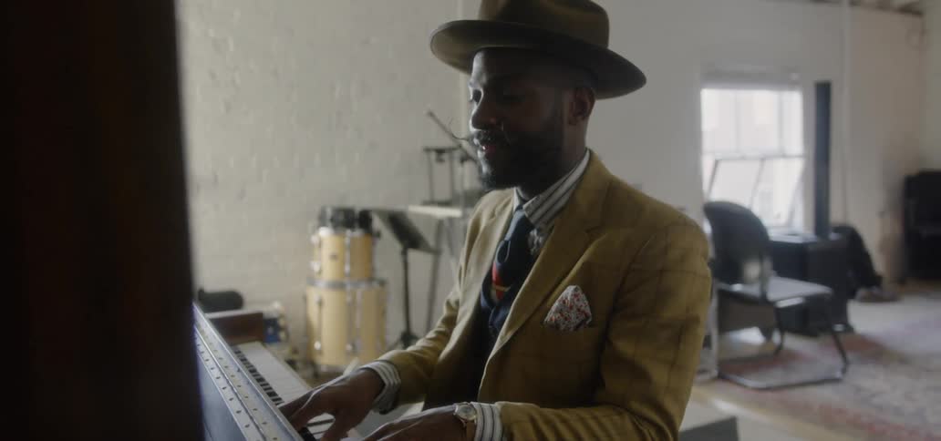 Man in suit is playing a piano
