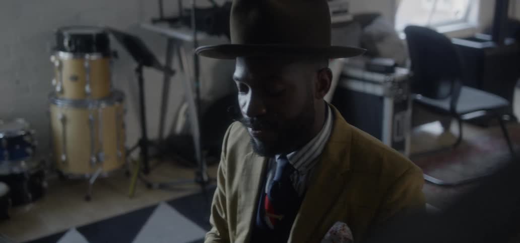 A man sings while playing a piano