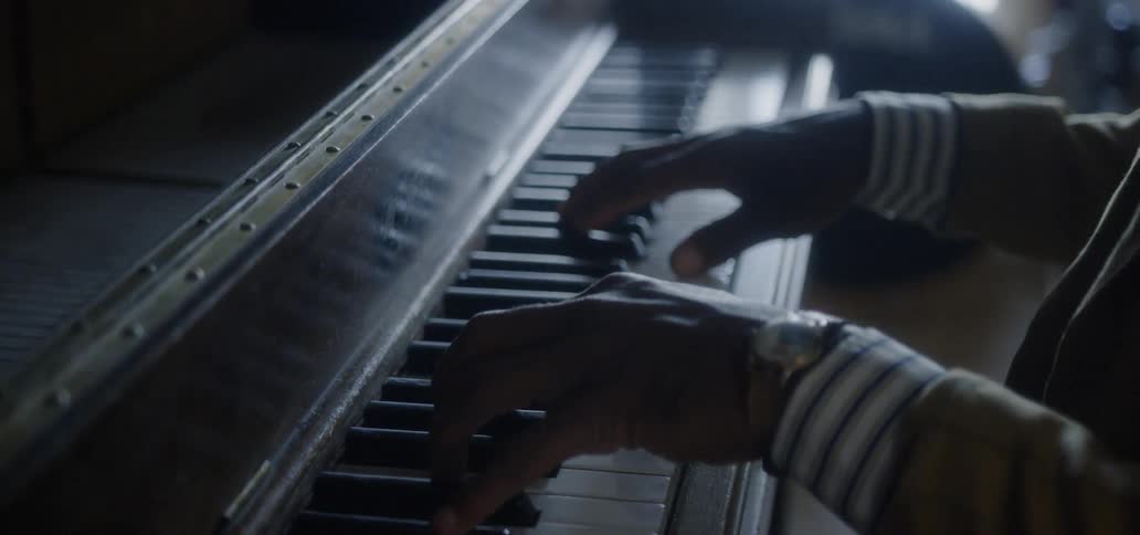 Man playing a piano in a dimly lit area