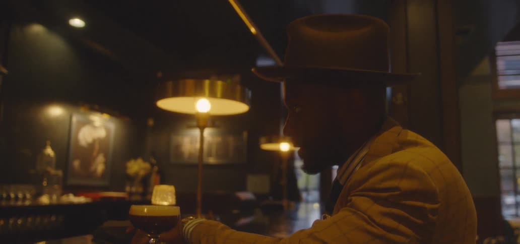 Man in suit is sitting at bar in night club