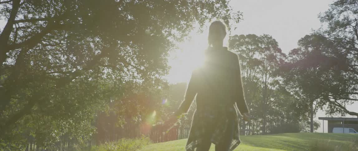 A woman walks through a yard in the daytime