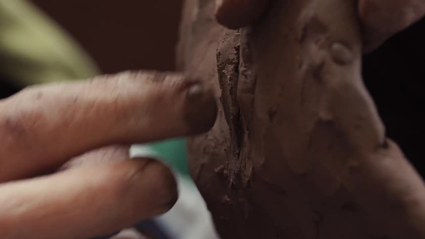 Person is forming a sculpture with clay