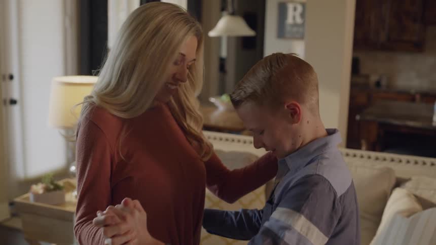 Mother is teaching her son how to dance in living room