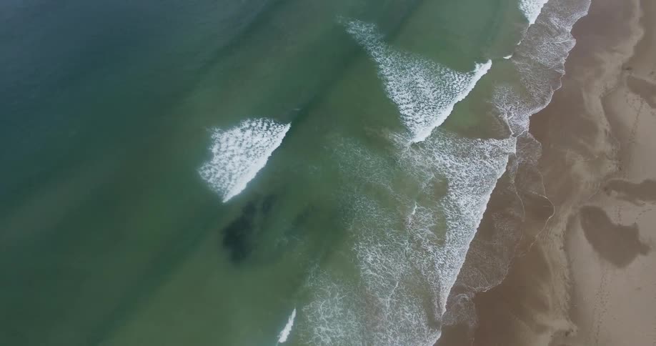 The large beach below has many waves crashing