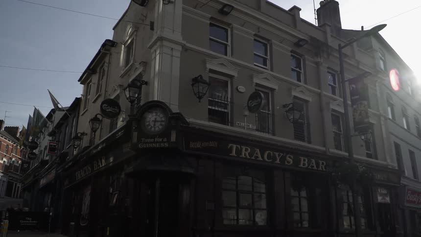 A building with a bar on a city street corner on a sunny day