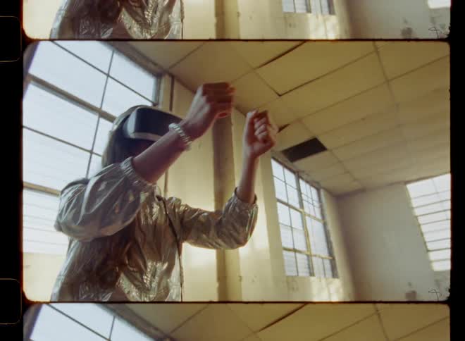 A woman stands in an empty room while using a vr headset