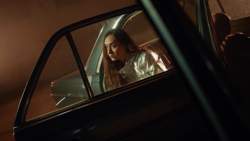 A woman sits in the backseat of a car