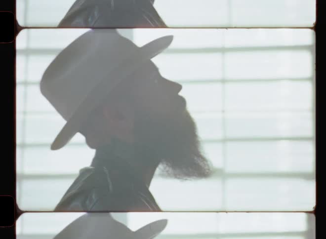 Man with a beard and hat plays guitar
