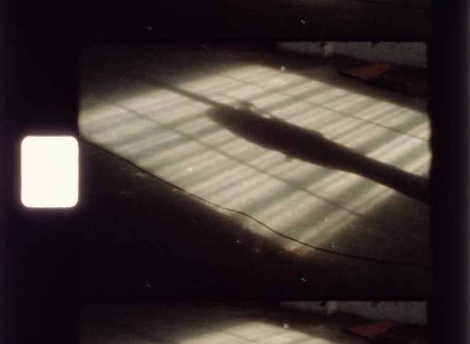 The guitar player is giving off a shadow in the dark room