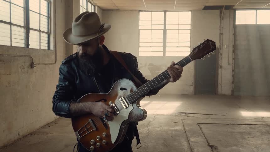 A man plays guitar in a run down building
