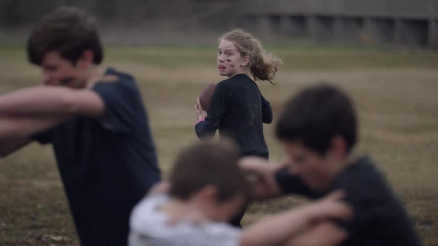 Children playing football in the mud. Young girl calling play.