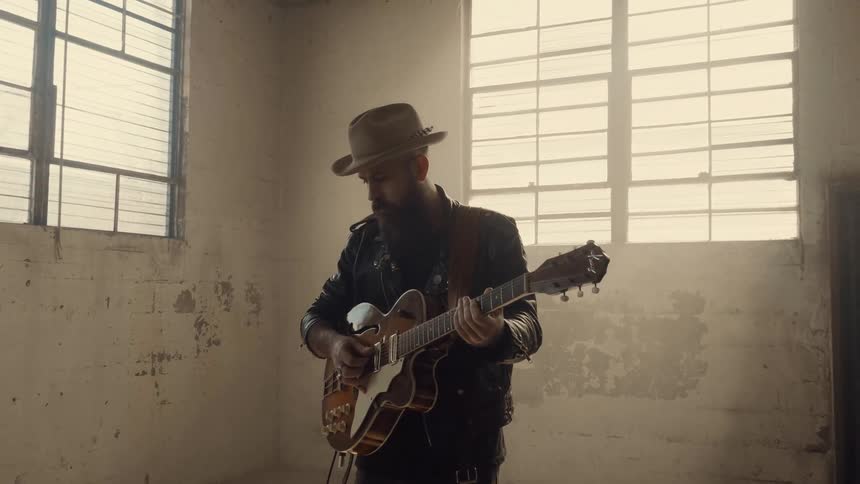 A man plays guitar in a run down building