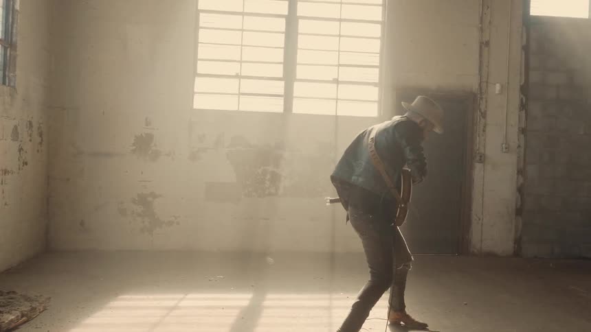 A guitar player is dancing as he plays the guitar