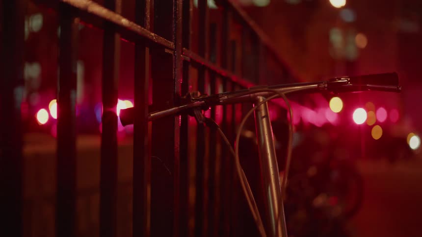 A scooter rests against the fencing as authority lights flash
