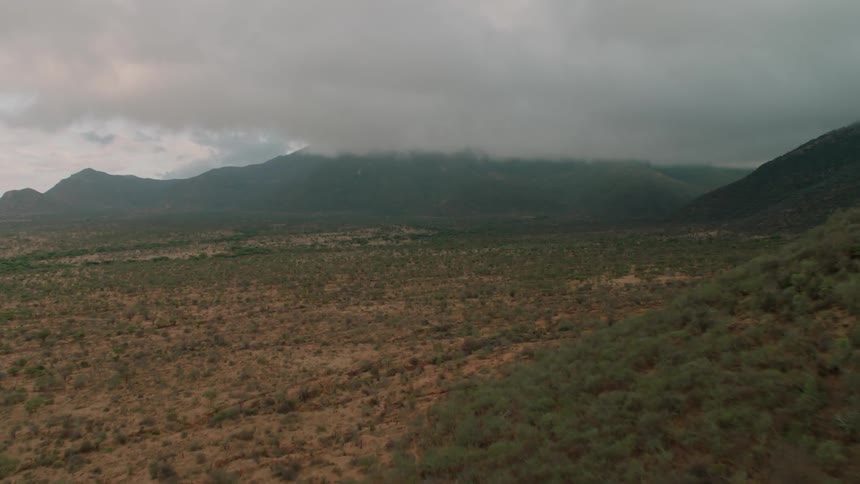Brown hills with some green here and there on a cloudy day