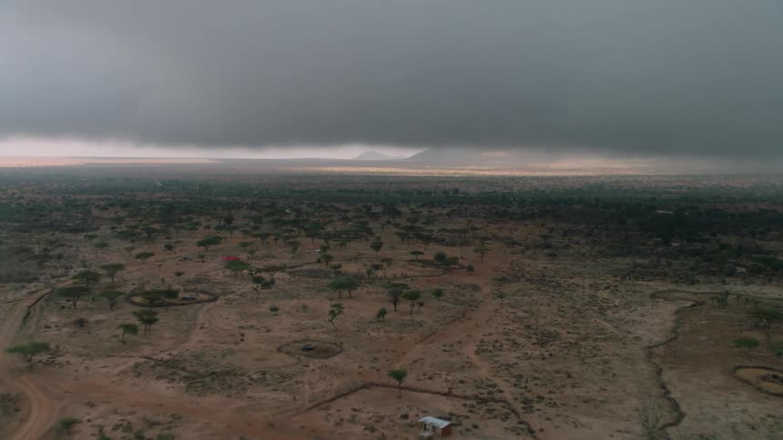 Storm clouds float over a rural landscape at sunset