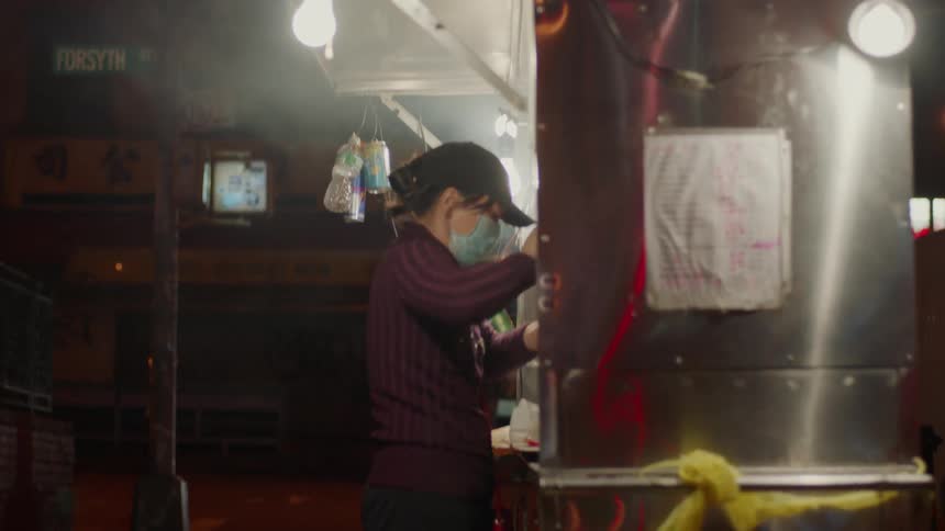 A woman works at a food cart