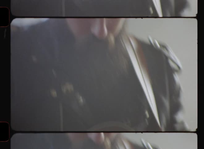 A man is playing guitar wearing a leather jacket