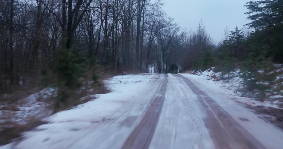 Snow covers a rural forest road