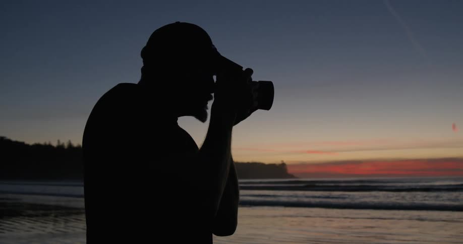 Man is photographing the ocean sunset