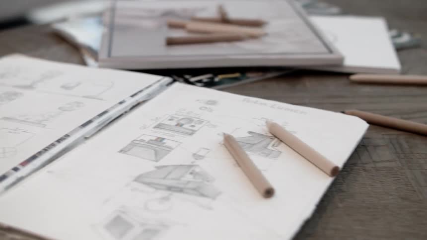 Notebooks with sketches lay on a table