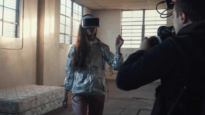 A man films a woman wearing a virtual reality headset