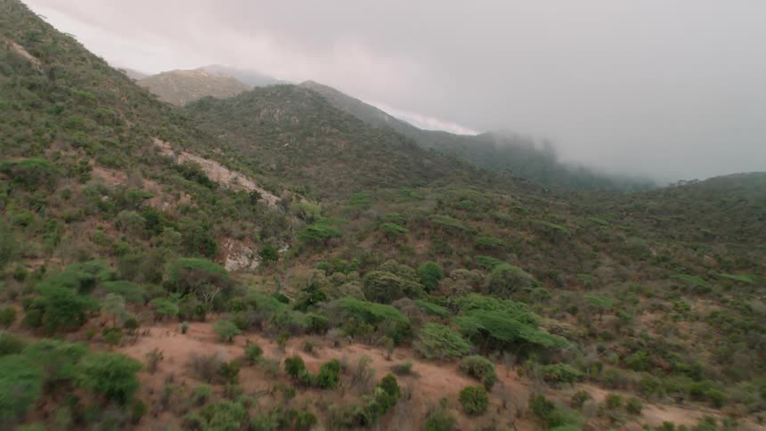Clouds float above a hilly landscape