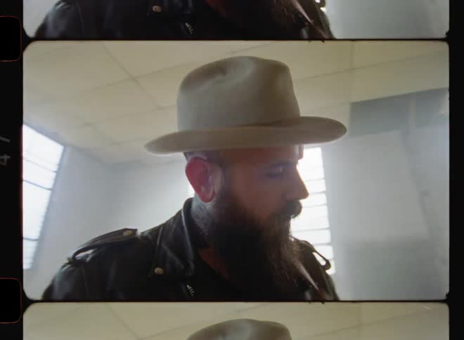 A man is playing guitar and nodding his head