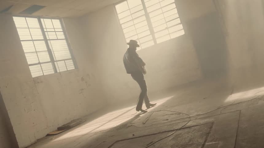 The man walks around playing his guitar