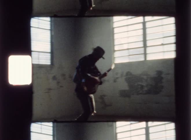 The man is performing playing his guitar