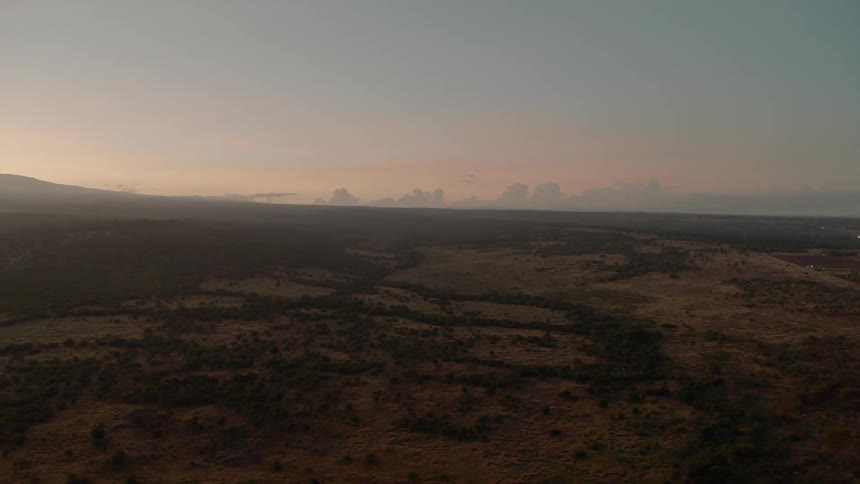 The sun is setting over the long green fields