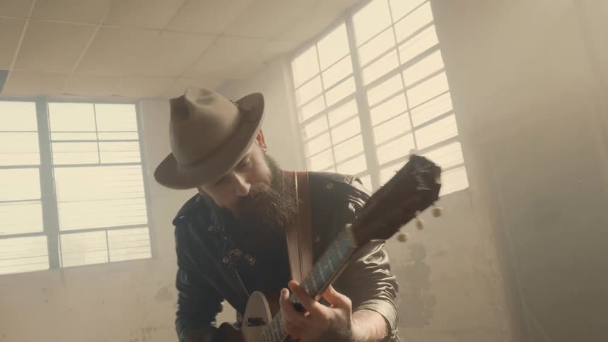 A man is playing guitar and dancing at the same time