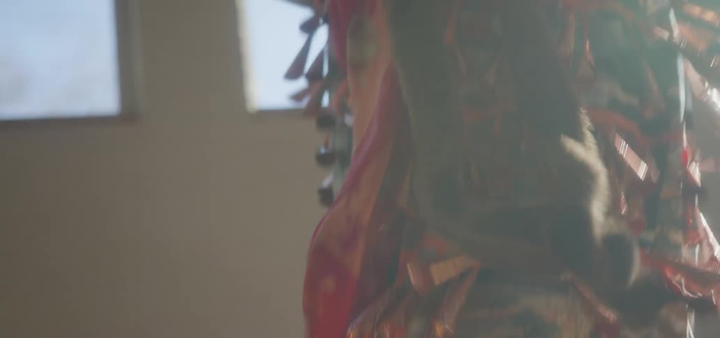 A woman is dancing as the tassels on her dress move up and down