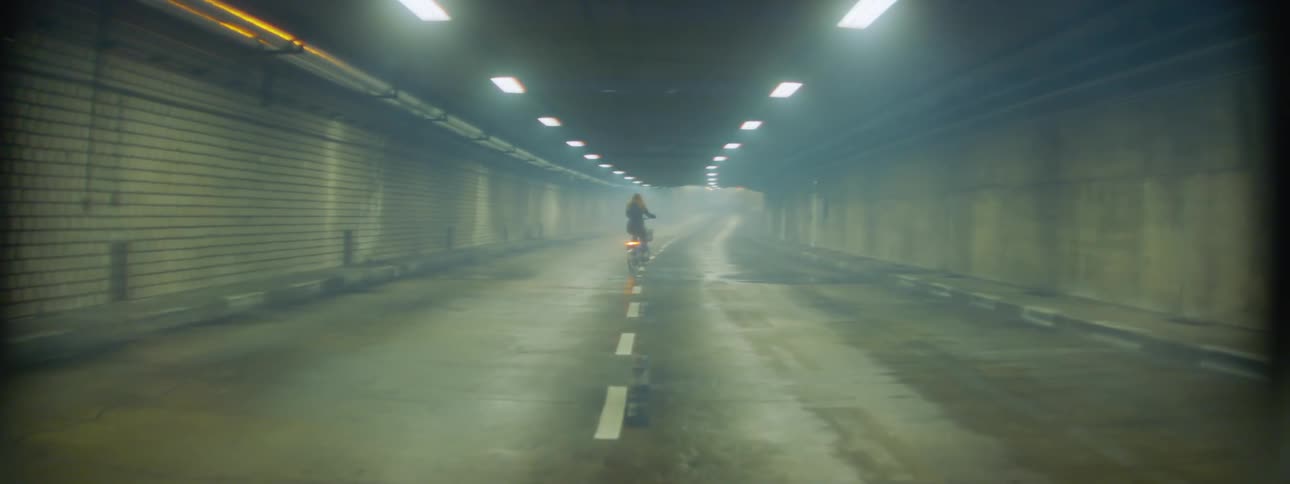 A person rides their bicycle in the tunnel