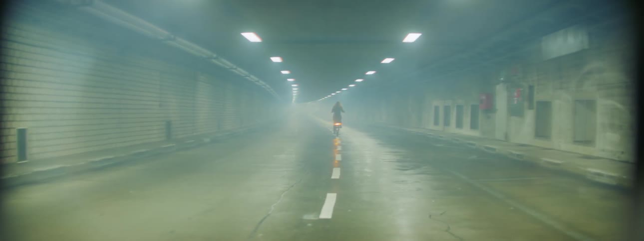 Person riding a bike in a foggy tunnel