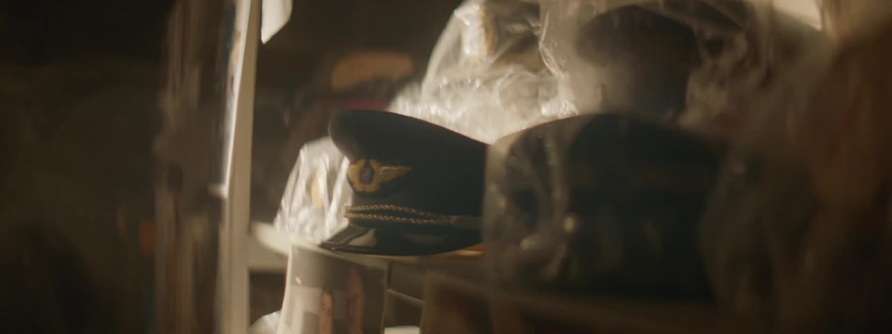 Hat on a shelf with many other things wrapped in plastic