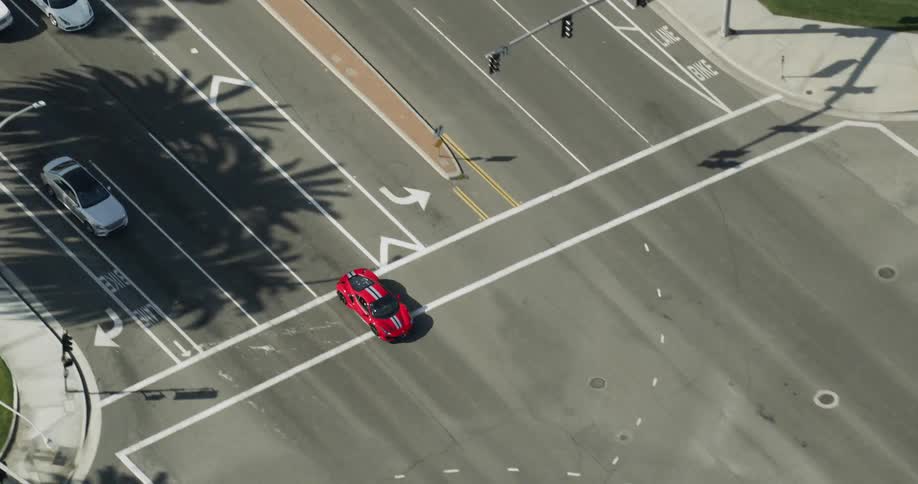 A sports car drives fast down a city highway