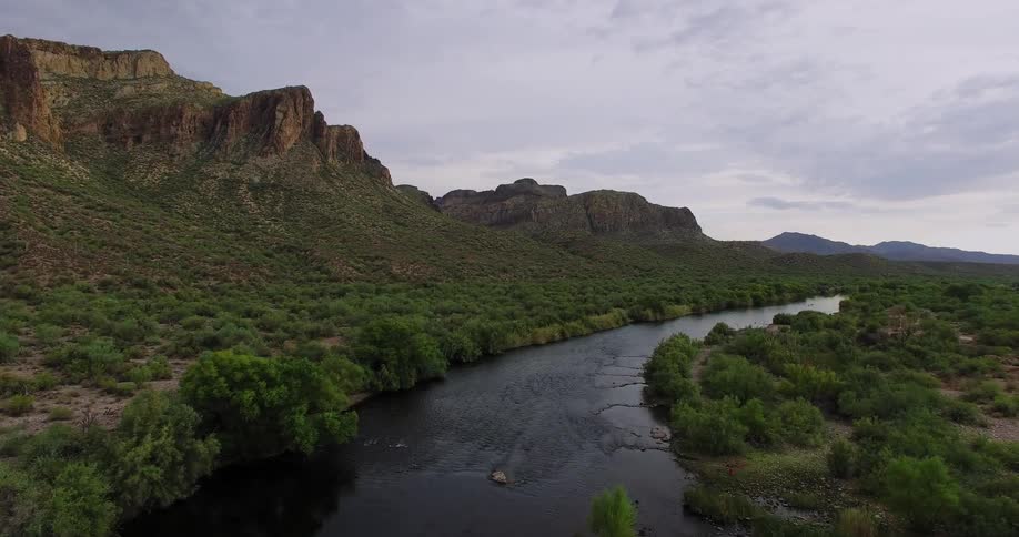 River flows through grassy hilly landscape