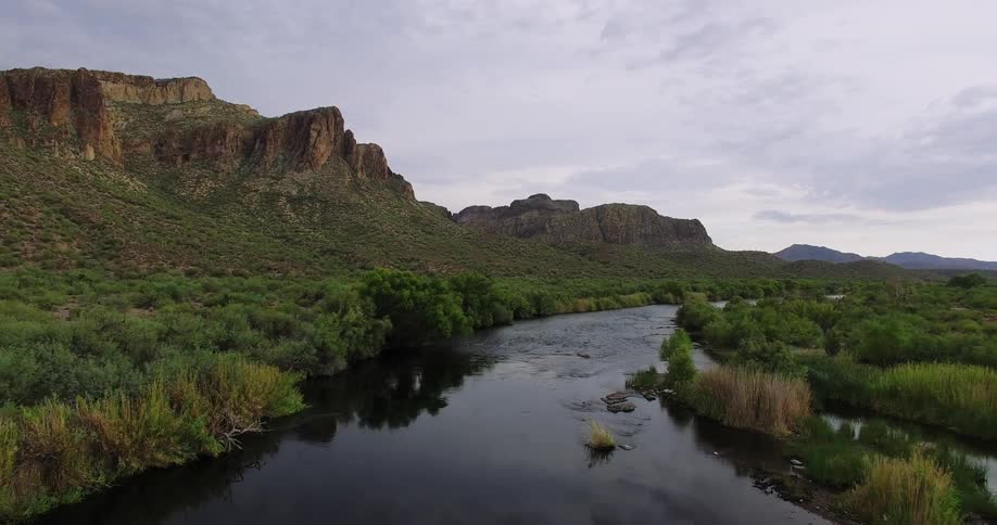 River flows through grassy hilly landscape