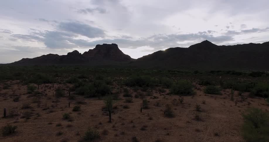 Brushy land and mountains with clouds overhead