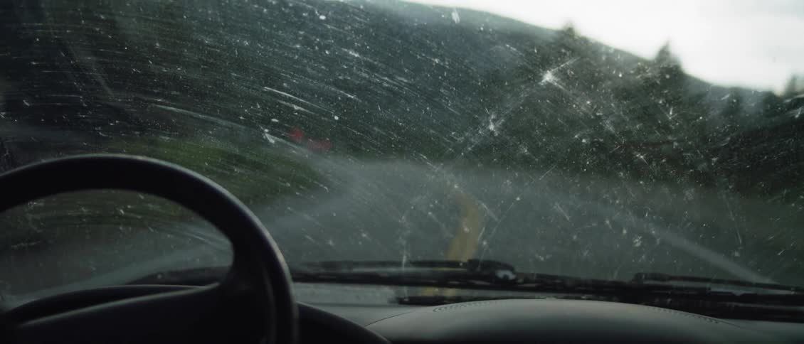 The sun is glaring inside the windshield of the moving car