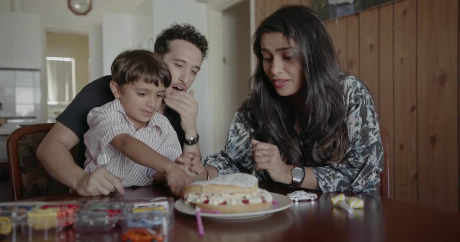 A young family cuts a cake