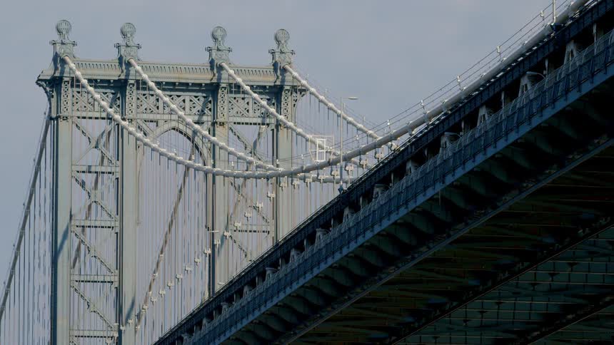 A large city bridge towers overhead