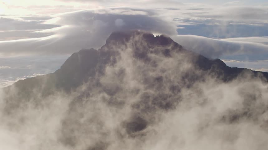 The clouds cover this tall mountain