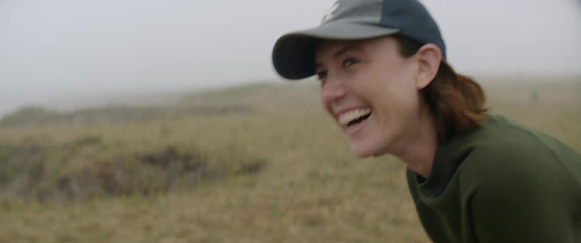 A woman laughs while looking out at nature