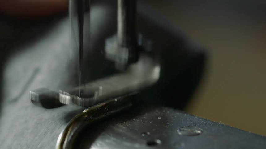 A woman sews a piece of fabric with a sewing machine