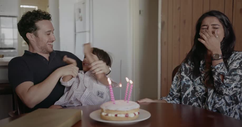 A mother father and child celebrate a birthday