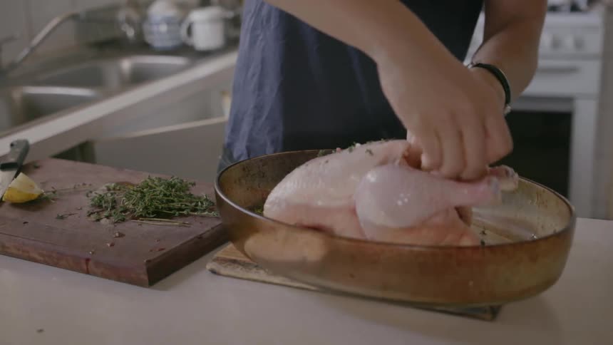 A man puts a piece of lemon in the chicken
