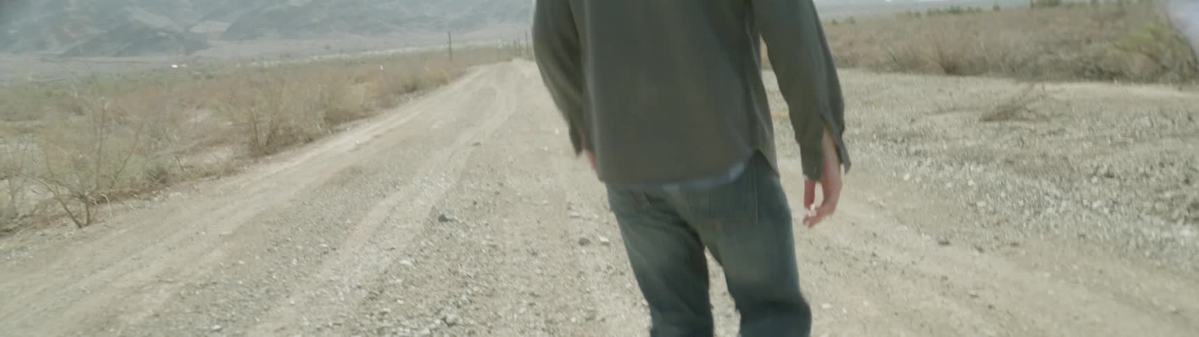 Someone is walking across a gravel road