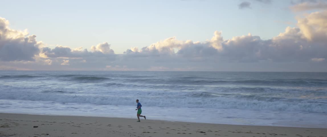 A man jogs down the beach